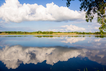 Lake with reeds and sky reflected in the water