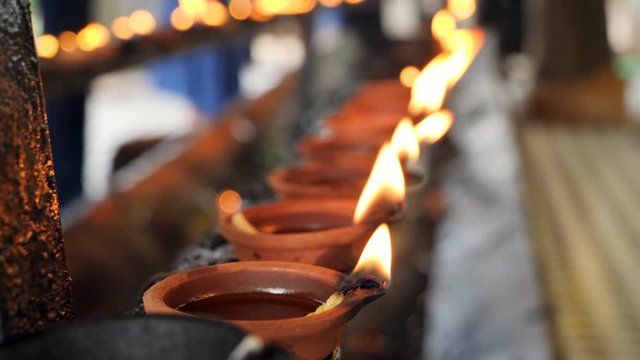 4k video of sacred fire in burning oil lanterns at hindu or buddhist temple on Sri Lanka