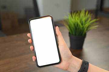 Hand holding blank screen of smartphone on the desk office and for graphic display montage.