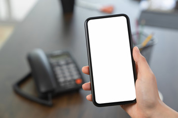 Hand holding blank screen of smartphone on the desk office and for graphic display montage.