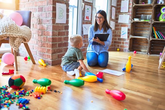 Young therapist woman speaking with child, counselor and behaviour correction at the office around toys