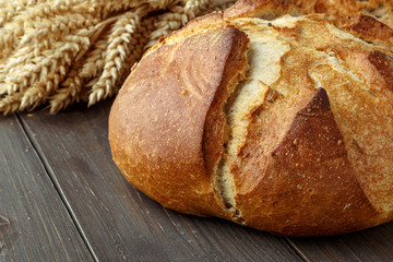 Freshly baked traditional bread on wooden table, with copy space, food closeup. Whole grain rye bread with seeds