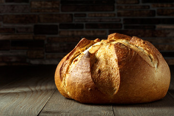 Freshly baked traditional bread on wooden table, with copy space, food closeup. Whole grain rye bread with seeds