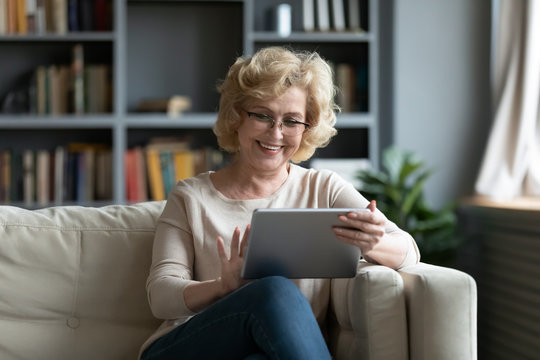 Middle-aged Woman Using Tablet Gadget At Home