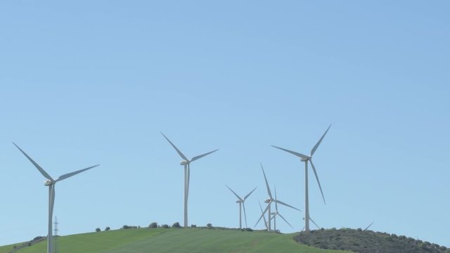Landscape of wind turbines of renewable energy in a hill moving with blue sky
