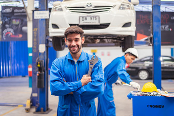 Mechanics holding wrench in the workshop garage. Auto car services concepts