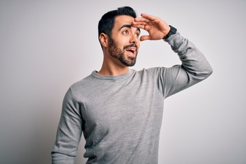 Young handsome man with beard wearing casual sweater standing over white background very happy and...
