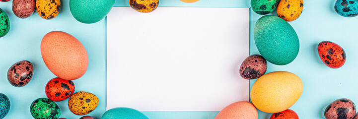 Stylish background with colorful easter eggs isolated on blue background with copy space. Flat lay, top view, mockup, overhead, template. Horizontal long web banner