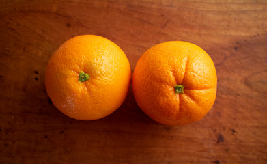 木皿の上の２つのオレンジ　Two fresh oranges on a wooden plate