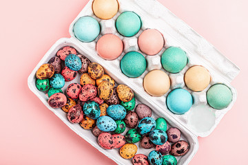 Stylish background with colorful quail, easter eggs with copy space for text on pink paper. Flat lay, top view, mockup, overhead, template