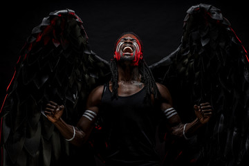 dark naked angel screaming from hopelessness and pain. black angel with strong muscles want to be...