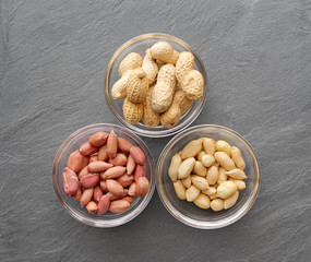 Top view of three bowls of peanuts, healthy snack