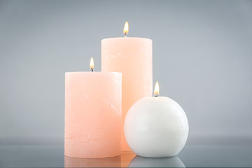 Fototapeta na wymiar Aromatic burning candles on light grey background