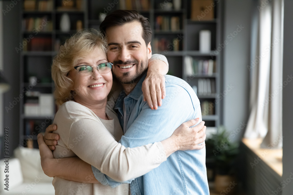 Wall mural Portrait of happy senior mom and grownup son cuddling