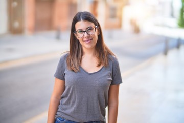 Young beautiful woman smiling happy and confident. Standing with smile on face at town street