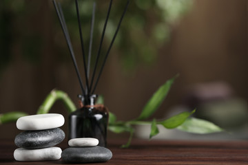 Spa stones on wooden table indoors. Space for text