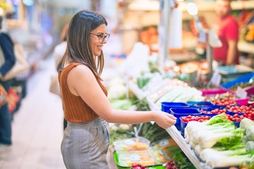 Young beautiful woman smiling happy and confident. Standing with smile on face buying food at supermarket