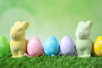 Fototapeta na wymiar Easter bunnies and painted eggs on green grass
