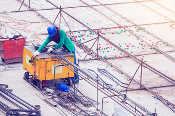 Construction worker and many deformed steel bar working with electric iron bending machine at the...