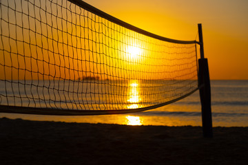 orange tropical sunset with volleyball net silhouette
