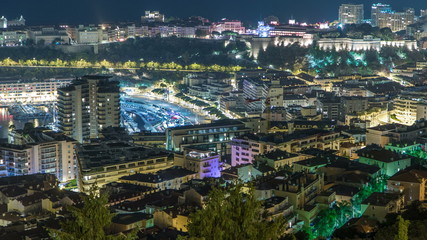 Cityscape of Monte Carlo, Monaco night timelapse with roofs of buildings and traffic on roads.