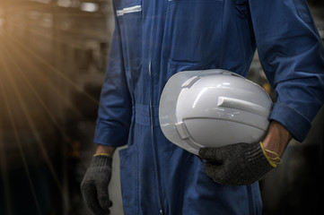 White helmet attached to the side of the factory technician. hand or arm of an engineer holding a...