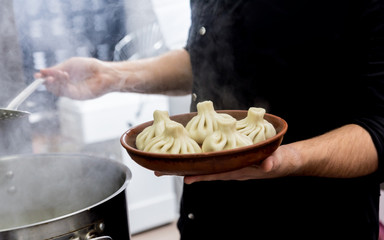 Chef coocking georgian khinkali or japanese wonton. Traditional meal 