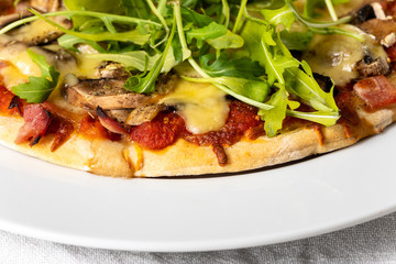 pizza on a plate with arugula
