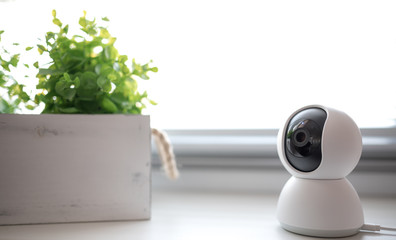 Indoor CCTV wireless IP security camera with 360 degrees rotating head, Concept of home security system for surveillance and protection, controlling via smartphone online.