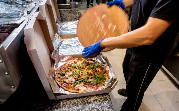 Tasty pizza in the delivery boxes. Kitchen.