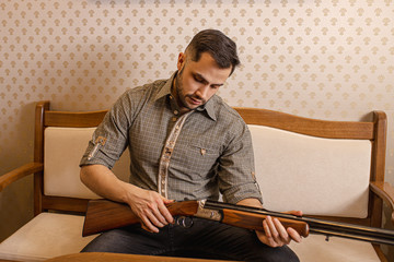 caucasian adult looking for a suitable rifle in guns store, he want to make purchase, buy rifle for...