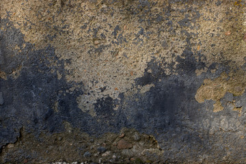 gray cracked concrete wall with protruding stones on its surface. old cement background.