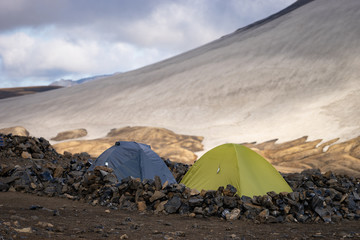 Camping with tents. Snowy mountain glaciers and storm wind. Iceland.