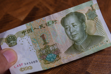 Male hand with a fan of 1 Renminbi or Chinese yuan  or abbreviated RMB banknote, the official currency of the peoples republic of china. On front side the portrait of Mao Zedong,  Paper Money of china