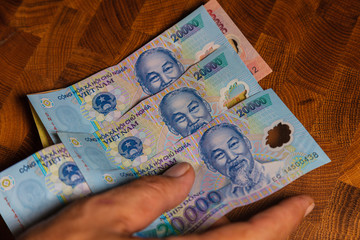 A collection of 20000 Vietnamese Dong  banknotes in a male hand. Man hand show Vietnam Dong...