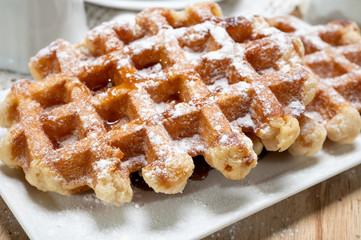 Tasty Belgian dessert, Brussels waffles with syrup and white sugar powder