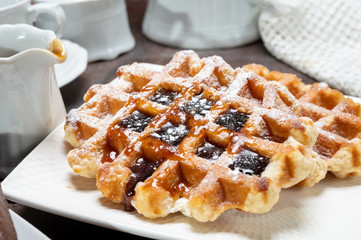 Tasty Belgian dessert, Brussels waffles with syrup and white sugar powder