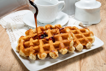 Tasty Belgian dessert, homemade Brussels sugar waffles with dark syrup