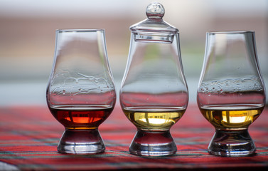 Special tulip-shaped glasses for tasting of Scotch whisky on distillery in Scotland, UK and red tartan
