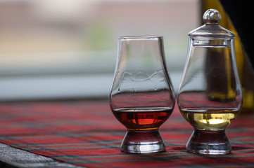 Special tulip-shaped glass for tasting of Scotch whisky on distillery in Scotland, UK and red tartan