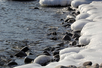 Icy stones on coast. Winter seascape