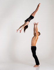 Muscular man throwing women in to air Isolated On White. Concept of trust, strength and courage 