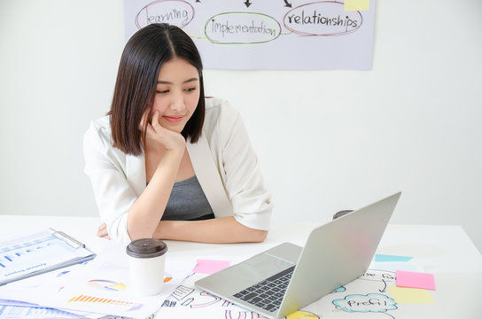 Smiling Beautiful Asian Woman Celebrate With Laptop Happy For Success Working. Agile For Startup Small Business Concept At Modern Office Or Co-working Space With Copy Space For Label Text