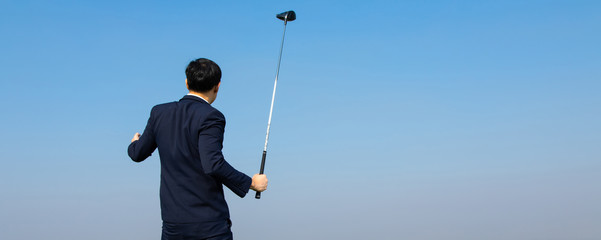Back view of Young Asian CEO Businessman wearing suits playing golf at the golf course. Portrait of Asian businessman. sucess and happy time
