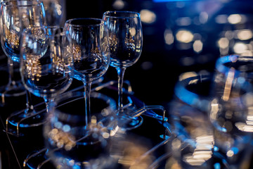 Wine and martini glasses in shelf above a bar rack in restaurant. 