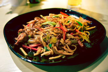 Japanese food on a black plate is on the table