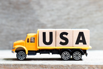 Truck hold letter block in word USA (abbreviation of United States of America) on wood background
