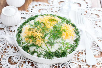 Traditional spring Russian Mimosa salad with fish and vegetables, selective focus