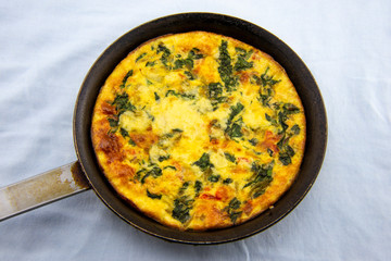 Frittata made of eggs, bacon, cheese and spinach