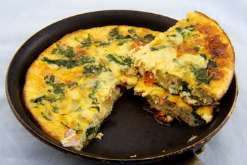 Frittata made of eggs, bacon, cheese and spinach